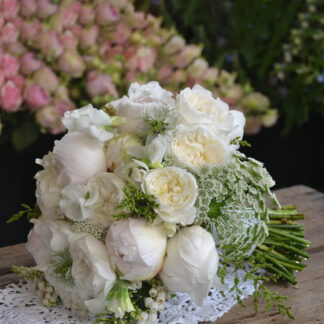 A breathtaking bridal bouquet featuring lush garden roses and elegant white peonies. The soft, ruffled petals create a romantic, timeless look, perfect for a classic and sophisticated wedding.